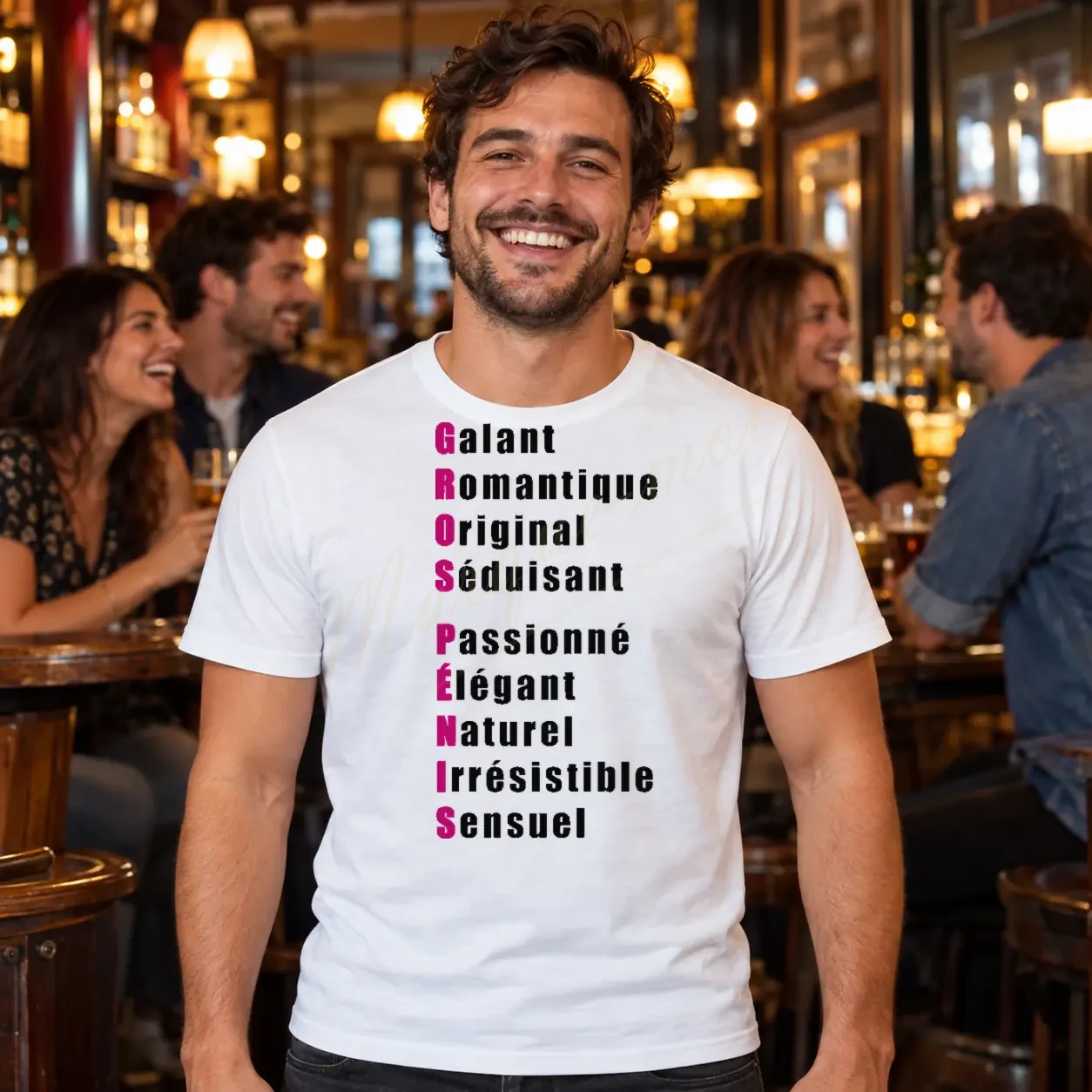 Homme dans un bar portant un tee-shirt blanc avec l’acrostiche humoristique « GROS PÉNIS » aux initiales roses sur le devant.