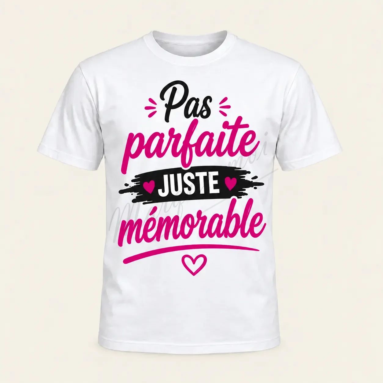 T-shirt blanc vu de face sur fond beige, avec le slogan « Pas parfaite, juste mémorable », un bandeau noir et des cœurs roses.