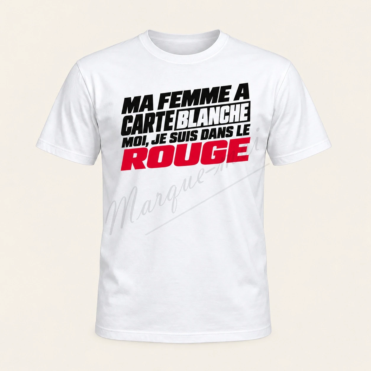 T-shirt blanc vu de face avec le slogan « Ma femme a carte blanche, moi je suis dans le rouge » en typographie noire et rouge, sur fond beige.